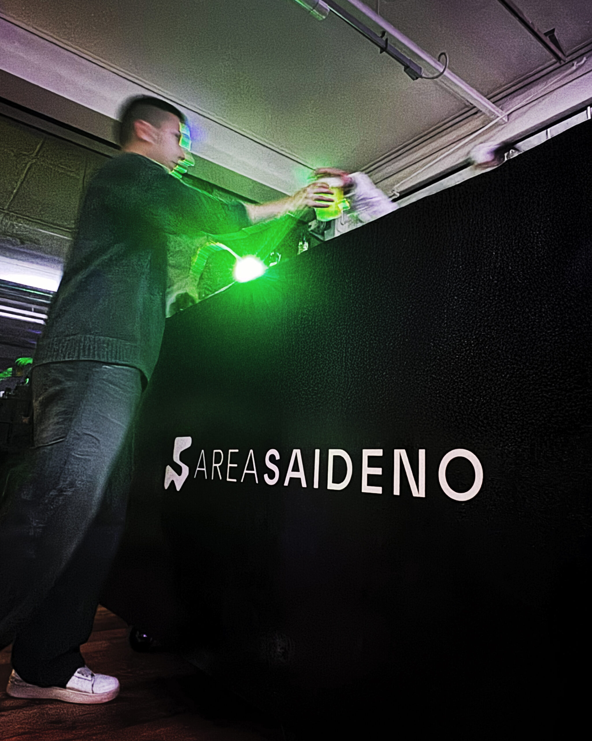 Ospiti in evento privato in location Area Saideno con buffet laterale e luci a soffitto.