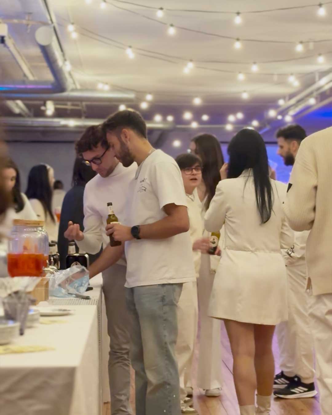 Ospiti in evento privato in location Area Saideno con buffet laterale e luci a soffitto.